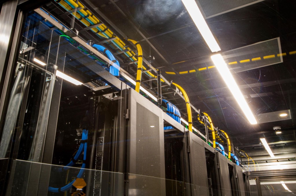 Data center server racks with organized overhead fiber and copper cabling